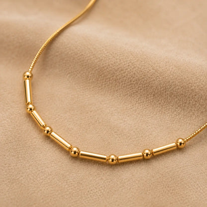 Gold necklace on a beige background