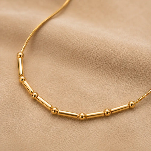 Gold necklace on a beige background